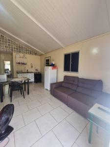 a living room with a couch and a kitchen at Condomínio Gold in Três Lagoas