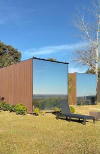 a bench sitting in the grass in front of a large screen at Destinar Tiny House in San Pedro +6 photos