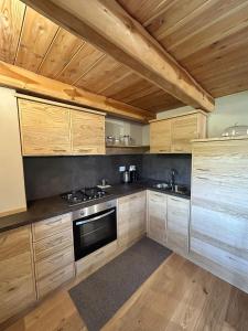 a kitchen with wooden cabinets and a stove top oven at La Mizoun dë Miquél in Ostana