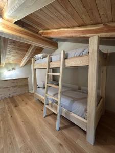 two bunk beds in a room with wooden ceilings at La Mizoun dë Miquél in Ostana