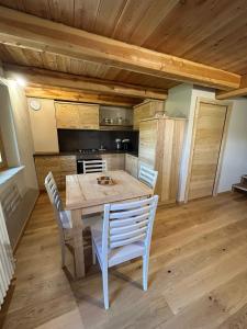 a kitchen with a wooden table and chairs at La Mizoun dë Miquél in Ostana +7 photos