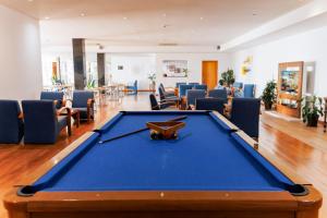 a pool table in a room with chairs at Hotel Colombo in Vila do Porto