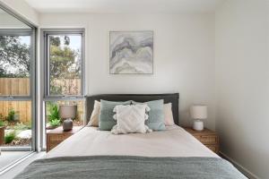 a bedroom with a bed with two lamps and a window at The Cape Collective 5 in Margaret River Town