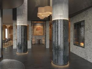 a lobby with marble columns and a painting on the wall at Hotel Le Morgane in Chamonix