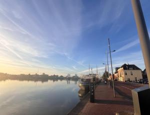 a view of a river with a boat in it at Herberg de Smederij in Kampen