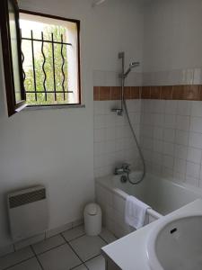 a bathroom with a tub and a sink and a window at Duplex T3 2 étoiles bord de lac 65mcarrés in Biscarrosse +49 photos