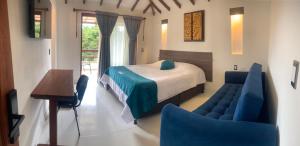 a bedroom with a bed and a table and chairs at hotel torres del viento in Villa de Leyva