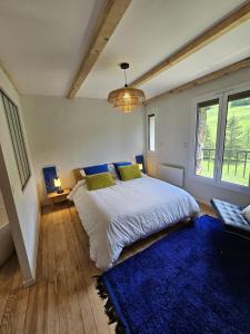 a bedroom with a large bed and a blue rug at La Parenthèse Enchantée Chalet in Beuil