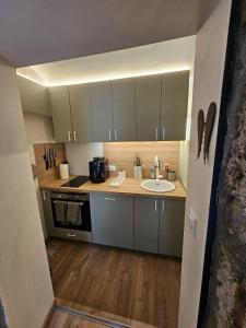a small kitchen with a sink and a microwave at La Parenthèse Enchantée Chalet in Beuil