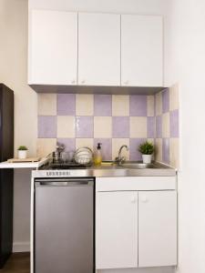 a kitchen with white cabinets and a stainless steel dishwasher at Studio Maisons-Alfort in Maisons-Alfort