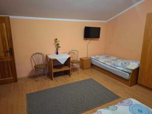 a small room with a bed and a table and chairs at Agroturystyka nad rzeczką in Szymany