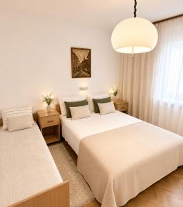a bedroom with two beds and a chandelier at Apartmani Selce za 2-3 osobe in Selce