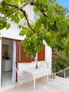 a white table and a chair on a patio at Apartmani Selce za 2-3 osobe in Selce