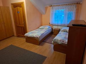 a small room with two beds and a window at Agroturystyka nad rzeczką in Szymany
