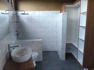a white bathroom with a sink and a toilet at Alam Sari GUEST HOUSE in Tabanan