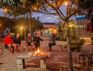 a group of people sitting around a fire in a park at Vila Caetité - Mucugê in Mucugê
