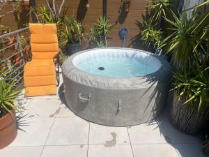 a large tub sitting on a patio with plants at SETE BELLE MAISON DE VILLE 121 m2 A 2 mn DE LA PLAGE et SPA in Sète