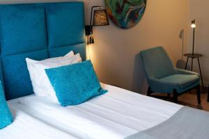 a bed with a blue headboard and a blue chair at Scandic Laholmen in Strömstad +64 photos