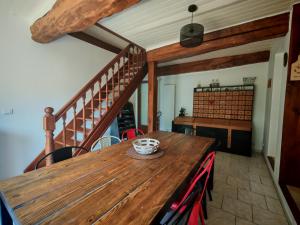 a dining room with a wooden table and a staircase at Le Pène de Béon in Aste-Béon +20 photos