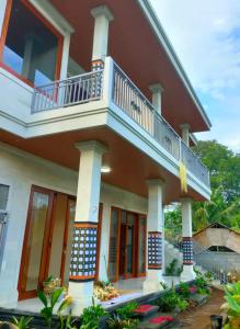 a house with a balcony on top of it at SARALA sidemen guest house in Sidemen