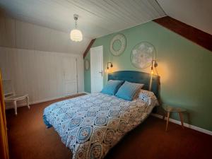 a bedroom with a bed with a blue comforter at Le Pène de Béon in Aste-Béon