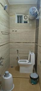 a small bathroom with a toilet and a window at Jazz Inn in Tiruvallūr