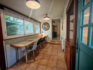 a dining room with a table and chairs and a clock at Le Pène de Béon in Aste-Béon