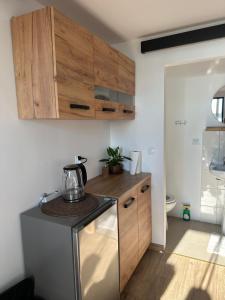 a kitchen with a stove and wooden cabinets at Noclegi nad jeziorem in Wiartel Mały