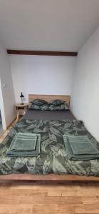 a bedroom with a bed with green comforter at Noclegi nad jeziorem in Wiartel Mały