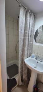 a bathroom with a sink and a shower curtain at Noclegi nad jeziorem in Wiartel Mały