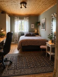 ein Schlafzimmer mit einem Bett, einem Schreibtisch und einem Stuhl in der Unterkunft Rosgarden in Hallstavik