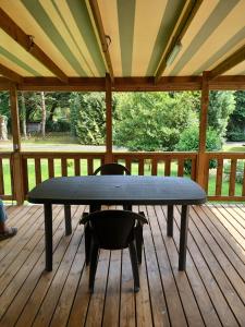 a table and a chair on a deck at Mobil home Vegas in Blangy-le-Château