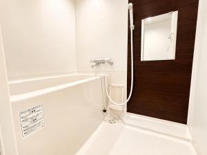 a white bathroom with a mirror and a sink at Rent菊水 -FIX HOME- in Sapporo +6 photos