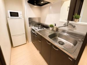 a small kitchen with a sink and a stove at Rent菊水 -FIX HOME- in Sapporo