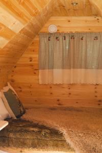 a bedroom in a log cabin with a window at Cabane Nuts palace in Vouillé