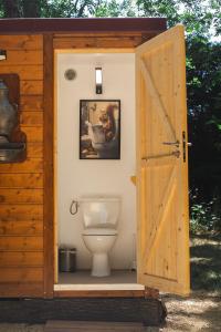 a bathroom with a toilet with a wooden door at Cabane Nuts palace in Vouillé