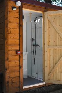 a shower in a wooden building with a sliding door at Cabane Nuts palace in Vouillé