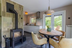 a kitchen and dining room with a wood stove at Stille Wille in Ballum