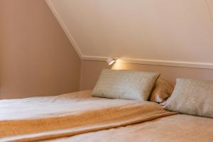 a bed with two pillows on it in a room at Stille Wille in Ballum