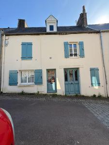 an old white house with blue shutters at Le Cosy in Coutances