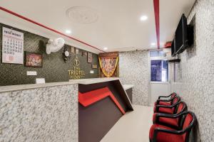 a restaurant with a counter and chairs in a room at Triotel Inn in Dhanbād