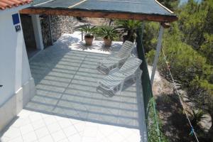 two white chairs on a porch with a roof at Apartment Nono Ivo in Vis