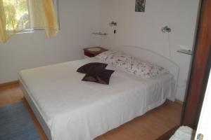 a bedroom with a white bed with a pillow on it at Apartment Nono Ivo in Vis