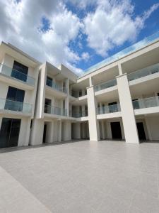 a large white building with a cloudy sky in the background at Mia Bella Madre Morogoro in Morogoro