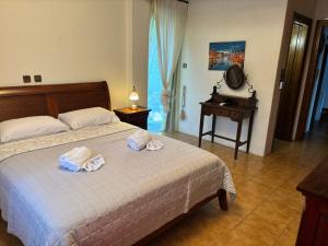 a bedroom with a bed with towels on it at Gate to the blue in Áyioi Apóstoloi