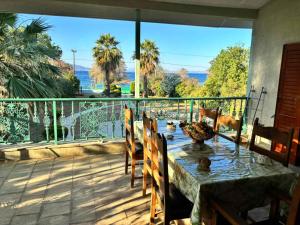 a table and chairs on a balcony with a view at Gate to the blue in Áyioi Apóstoloi