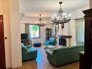 a living room with green furniture and a fireplace at Gate to the blue in Áyioi Apóstoloi