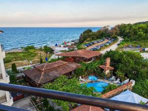 a view of a resort with a swimming pool and the ocean at Coral Guest House in Obzor