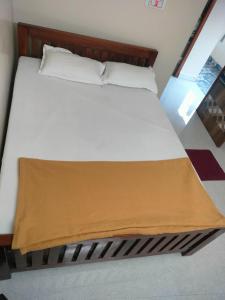 a bed with a brown blanket on top of it at Guru Room in Tiruvannāmalai