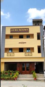 a building with a sign for a hotel at Guru Room in Tiruvannāmalai